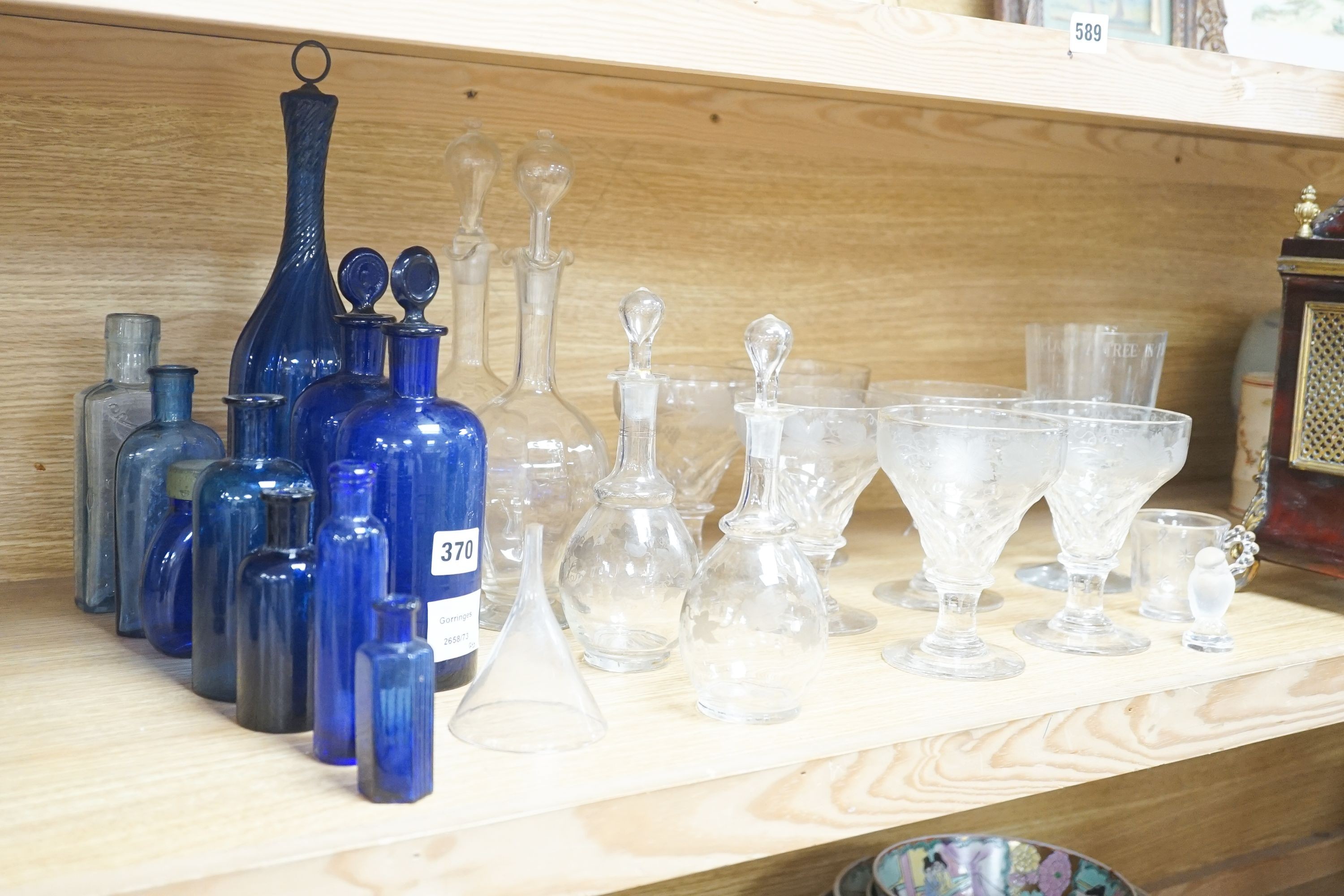 A Lalique frosted glass bird, etched Wedgwood ‘plant a tree ‘73’ glass, other etched glasses, decanters and blue glass pharmacy bottles